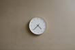 © neekmason/Stocksy - modern minimal analog clock on tan wall
