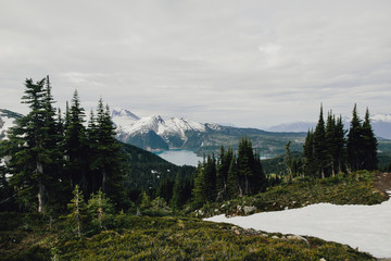 Mountains landscape below light clouds with glacial lake