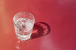 Glass of water on the red-orange table with copy space