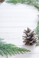 Christmas decoration background: pine and cypress cones with twigs on white wood table