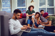 © Studio Romantic - A guy is a student with a laptop on the background of friends in the room.