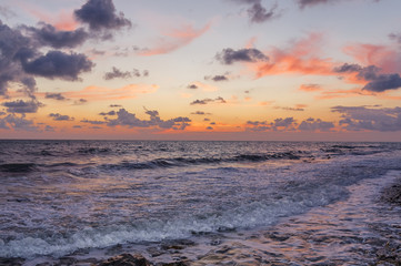 Wall Mural - Sunset through the clouds over the sea.