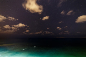 Wall Mural - Clouds and stars over the night sea.