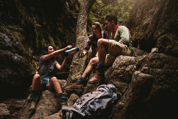 Wall Mural - Friends taking coffee break while hiking in rocky mountain