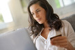 © goodluz - Brunette woman connected with laptop, shopping online