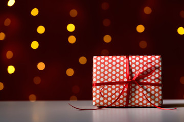 Wall Mural - Christmas gift box on a shiny light dark red background