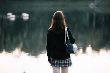 Portrait of asian japanese school girl costume looking at park outdoor film vintage style