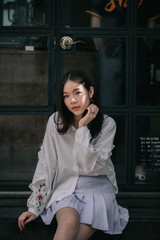 Wall Mural - portrait of asian girl with white shirt and skirt looking in outdoor nature vintage film style