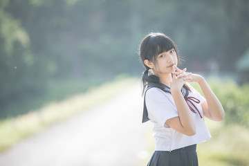 Portrait of asian japanese school girl costume looking at park outdoor film vintage style