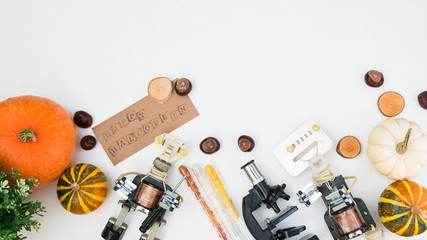 Happy halloween at STEM education school. Flat lay. Metal Robot and pumpkin all around. Free spase for text.