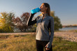 © South House Studio - young brunette woman in the park drinking a protein shake and doing sport