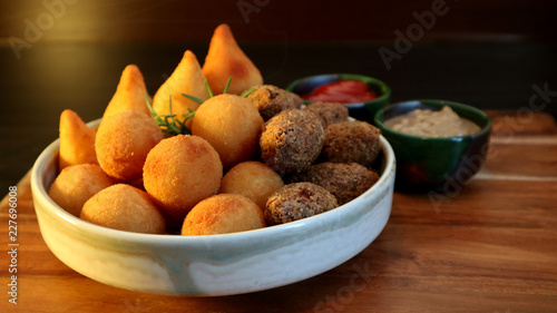 Fotomural Traditional Brazilian snacks coxinha and quibe on wooden dark background
