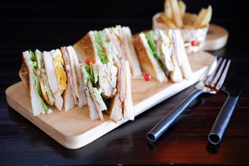 Wall Mural - club sandwich with french fries on wooden table 