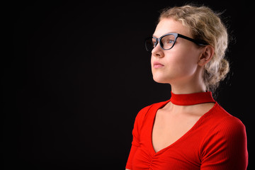 Young beautiful woman with blond curly hair against gray backgro