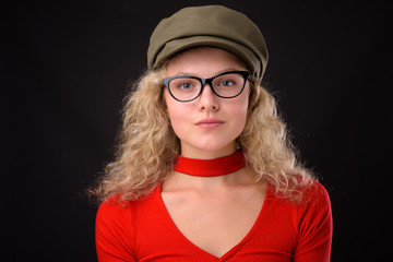 Young beautiful woman with blond curly hair against gray backgro