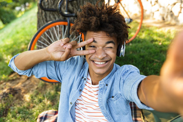 Poster - Cheerful young african teenager with bicycle outdoors