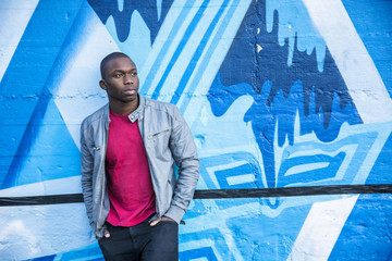 Portrait of a hot black man in front of graffiti wall, posing for camera