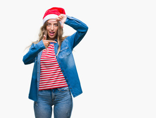 Poster - Beautiful young blonde woman wearing christmas hat over isolated background smiling making frame with hands and fingers with happy face. Creativity and photography concept.