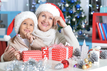 Wall Mural - Portrait of a woman and child girl celebrating Christmas