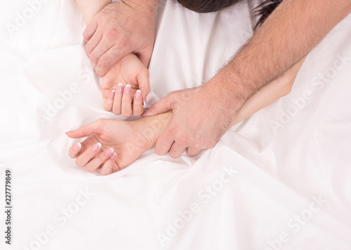 Photographie Hands of couple who have sex on white crumpled sheet, focus on hands