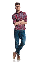 Canvas Print - confident casual man wearing a plaid shirt stands cross-legged