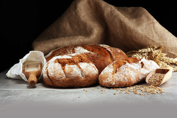 Different kinds of bread and bread rolls on board from above. Kitchen or bakery