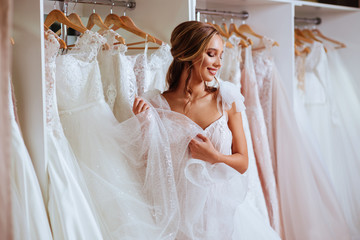 Beautiful bride is trying on an elegant wedding dress