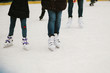 Skaters skating on iceskating ring in european city center in winter holidays.  Kids playing on white ice skating ring, healthy activity. Child legs in white skates