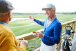 © pressmaster - Two aged men with tea having talk in outdoor cafe about new area for playing golf