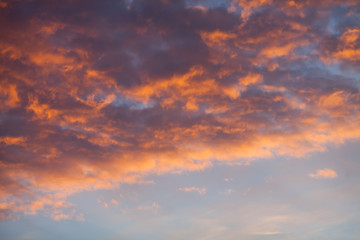 The clouds are illuminated by the orange light of the evening sun