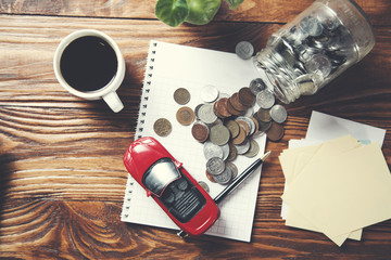 coins in glass jar with car model