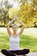 © Olesia - Girl meditates while practicing yoga outdoors in park