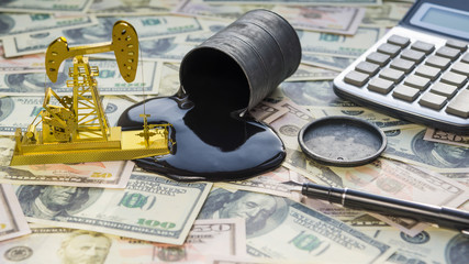 Wall Mural - Gold oil pump rocking, spilled a barrel on money dollars banknotes, a calculator and a pen. business concept idea. teamwork, oil production. buying, sale, auction, fuel prices