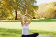 © Olesia - Girl meditates while practicing yoga outdoors in park
