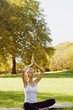 © Olesia - Girl meditates while practicing yoga outdoors in park