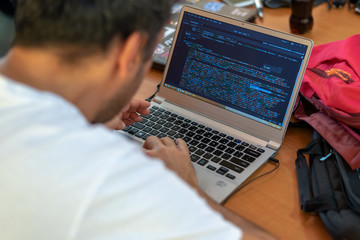 Young man programming on a laptop