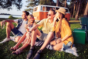 Wall Mural - Hipster friends by camper van at festival on a summers day.