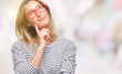 © Krakenimages.com - Young beautiful woman wearing glasses over isolated background with hand on chin thinking about question, pensive expression. Smiling with thoughtful face. Doubt concept.