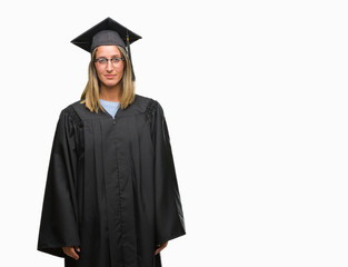 Poster - Young beautiful woman wearing graduated uniform over isolated background with serious expression on face. Simple and natural looking at the camera.