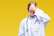 © Krakenimages.com - Beautiful young blonde doctor woman wearing medical uniform over isolated background smiling and laughing with hand on face covering eyes for surprise. Blind concept.