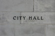 © KilmerMedia - Metal letters reading CITY HALL are shown affixed to a concrete exterior wall of a municipal building.