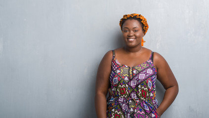 Sticker - Young african american woman over grey grunge wall wearing orange braids with a happy and cool smile on face. Lucky person.