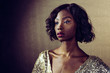 © Carlos David - Close up portrait of a beautiful woman in golden sequin dress looking off camera