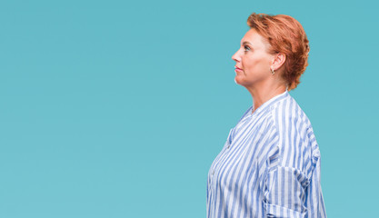 Poster - Atrractive senior caucasian redhead woman over isolated background looking to side, relax profile pose with natural face with confident smile.