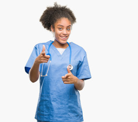 Wall Mural - Young afro american doctor woman over isolated background pointing fingers to camera with happy and funny face. Good energy and vibes.