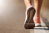 Running shoe closeup of woman running on road with sports shoes