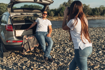 Wall Mural - Happy Couple on Roadtrip into the Sunset in SUV Car