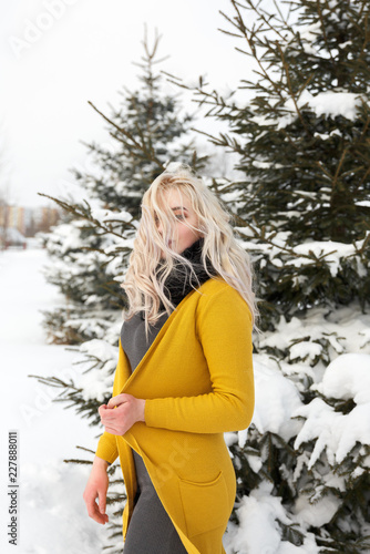 Fashion Portrait Of A Blonde Girl In A Yellow Knitted Sweater In