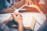 Fototapeta  - Christians are congregants join hands to pray and seek the blessings of God, the Holy Bible. They were reading the Bible and sharing the gospel with copy space.