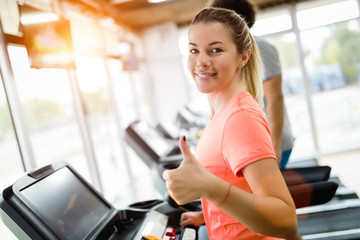 Wall Mural - Pretty girl working out in a treadmill at the gym